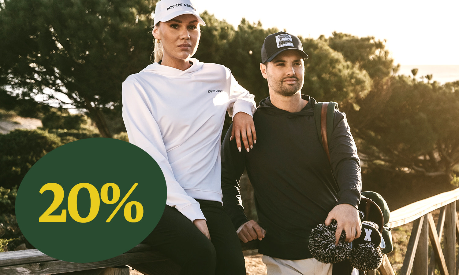 To personer i sportstøj står udendørs på en træbro, med en stor grøn cirkel, der viser teksten "20%".