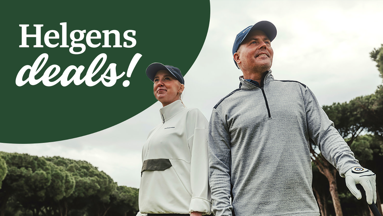 Två golfspelare står utomhus på en golfbana, klädda i sportkläder och kepsar, omgivna av gröna träd.