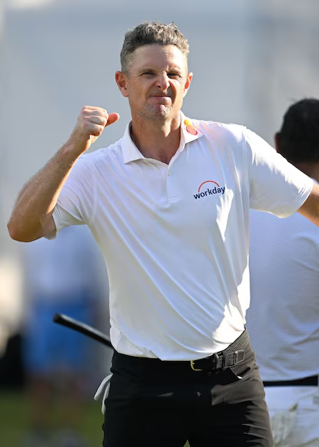 Mann im weißen Poloshirt mit "Workday"-Logo feiert mit geballter Faust im Freien auf einem Golfplatz.