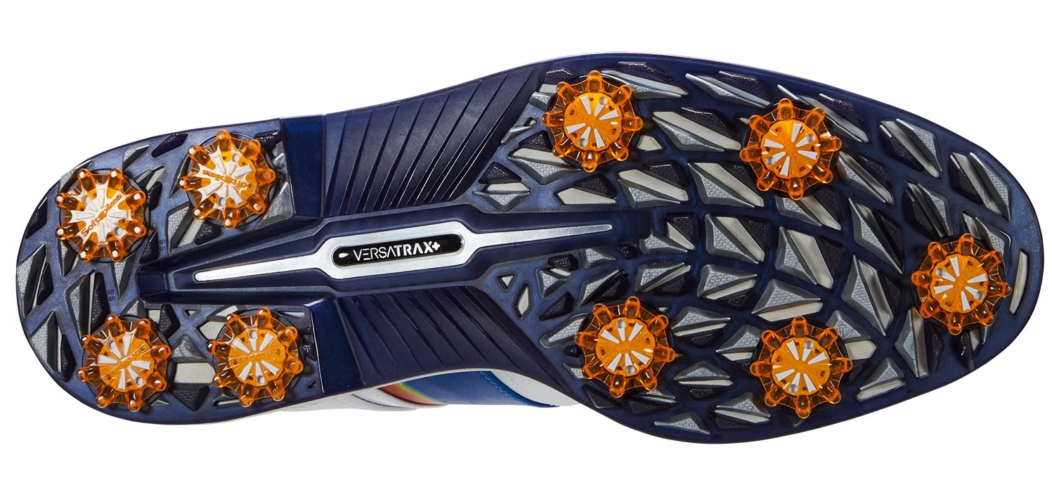 Undersiden af en golfsko med blå og orange mønstret sål, udstyret med ni Softspikes og teksten "Versatrax+".