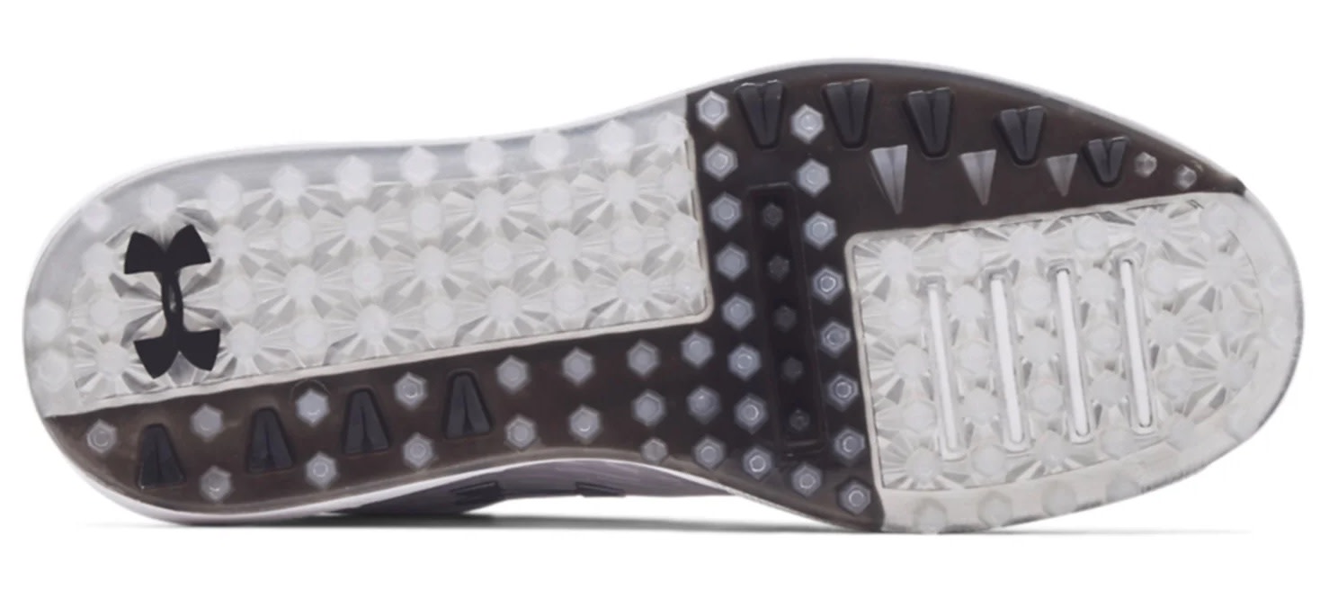 Undersiden af en sportskosål med mønstret gummioverflade, sorte detaljer og Under Armour-logo på venstre side.