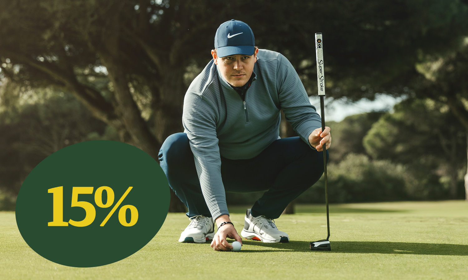 Mand i golfbeklædning placerer en golfbold på greenen med en putter, teksten "15%" vises i et grønt felt til venstre.