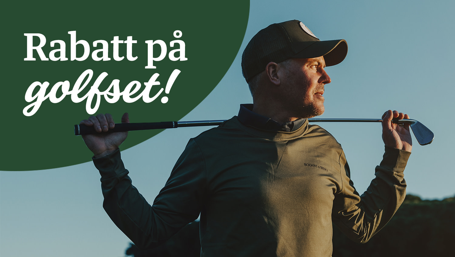 Man i keps håller en golfklubba bakom nacken och tittar åt sidan utomhus i kvällsljus.