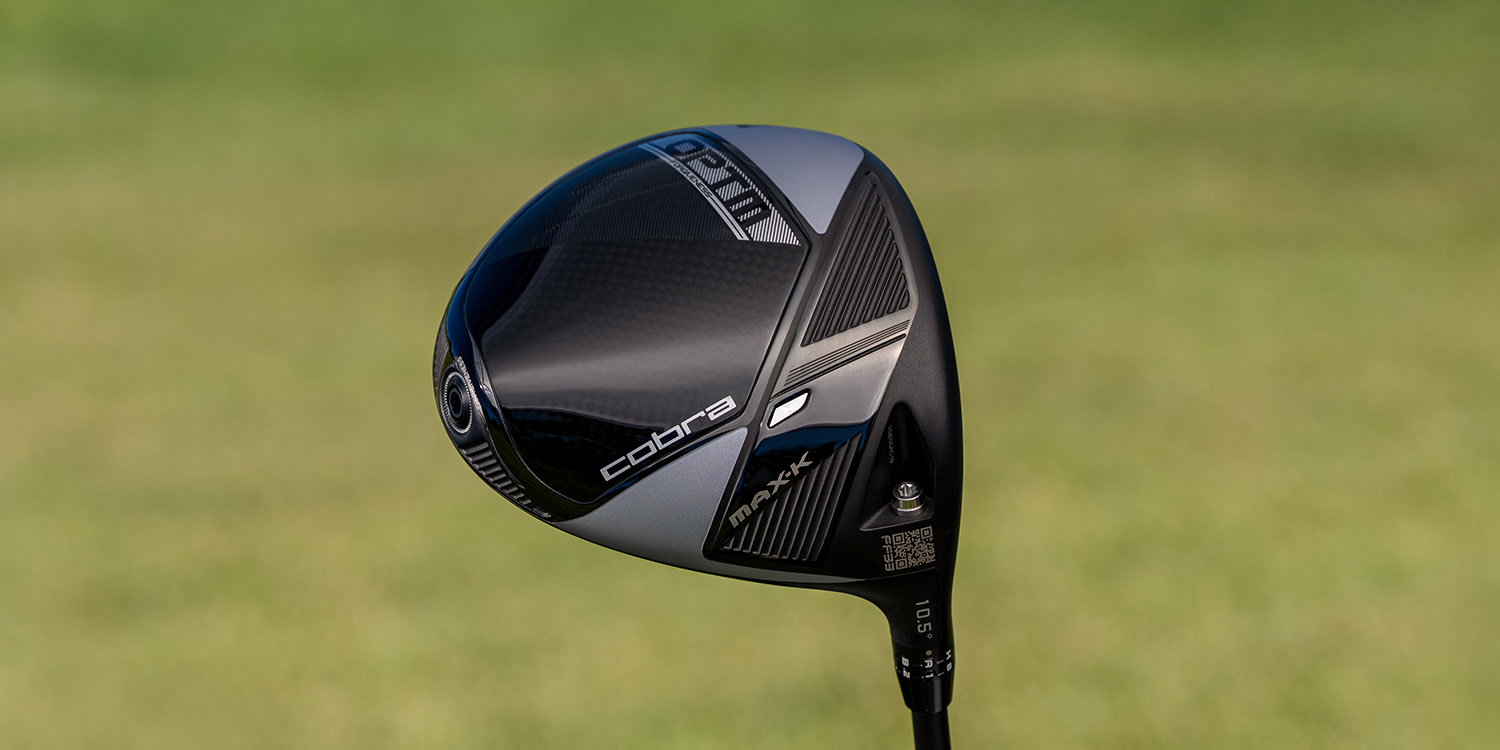 Cobra-merkkinen MAX-X-mallinen golfmaila pidetään esillä sumeaa vihreää taustaa vasten.