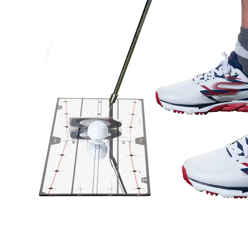 Golfspelare med vita skor tränar puttning med en spegel och en golfboll på en träningsmatta.