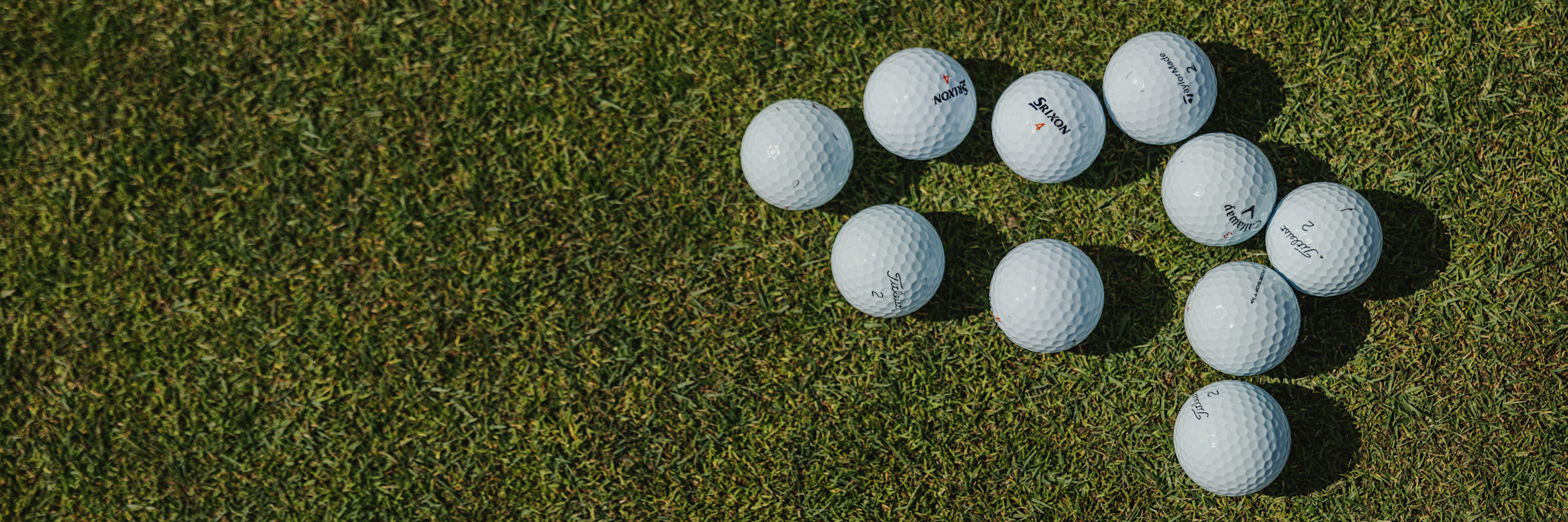 Bild på golfbollar liggandes på en green.