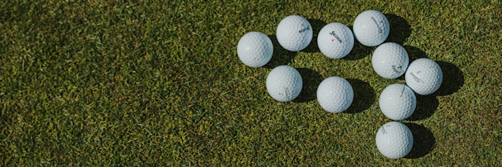 Bild på golfbollar liggandes på en green.