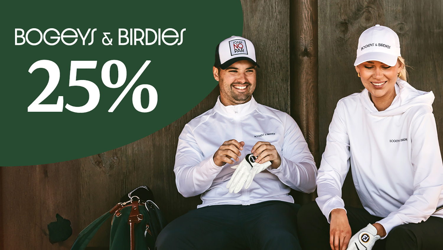 Två golfare går sida vid sida med golfbagar över axeln under en klar blå himmel.