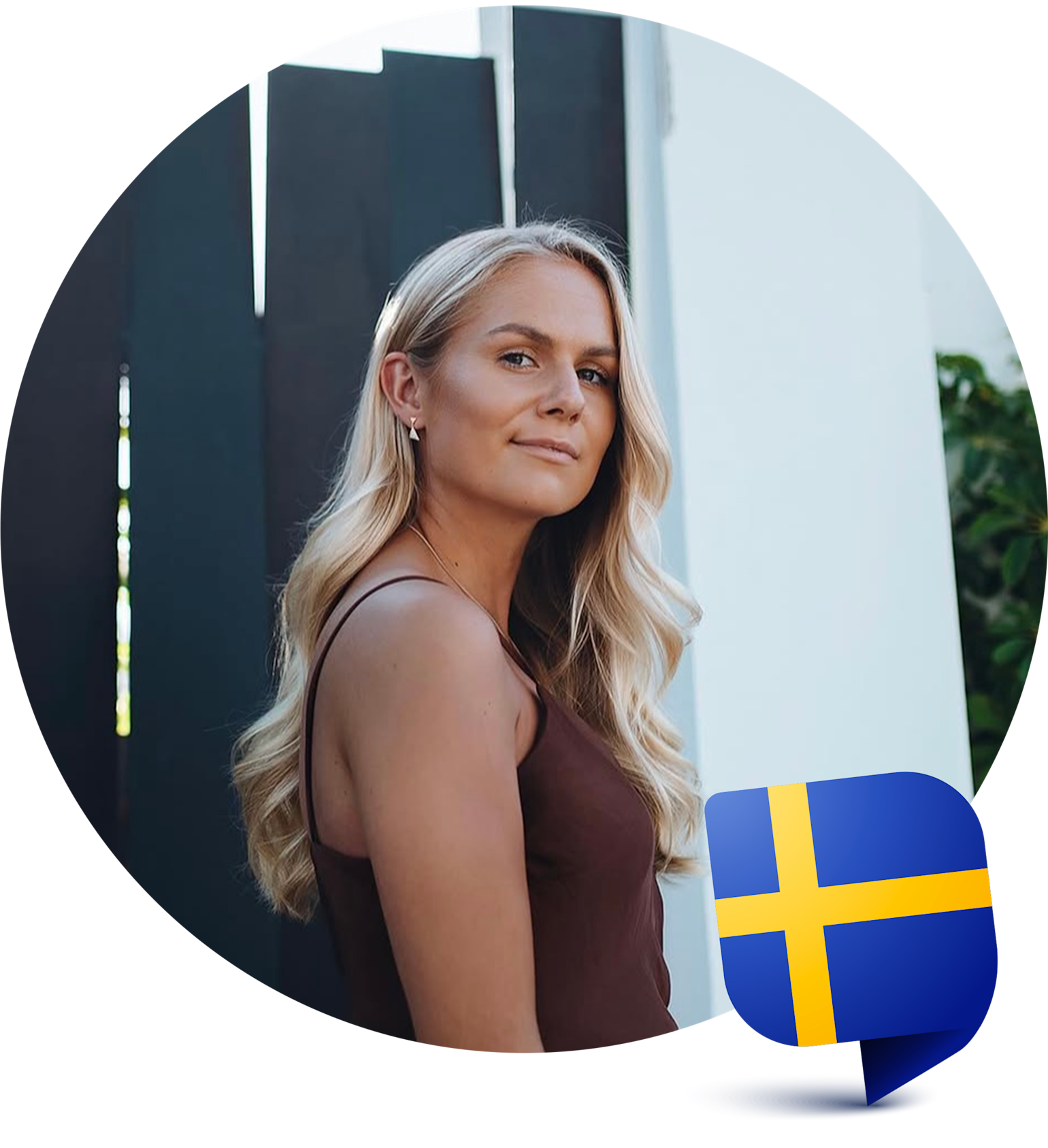 Frau mit langen blonden Haaren steht draußen an einem dunklen Zaun, eine schwedische Flaggen-Ikone ist in der Ecke zu sehen.