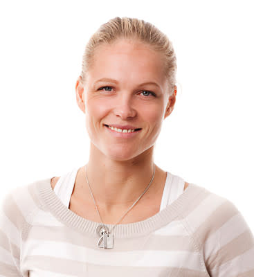 Frau mit blondem Haar im Pferdeschwanz lächelt in die Kamera, trägt einen hellen gestreiften Pullover und eine Halskette mit Anhänger.