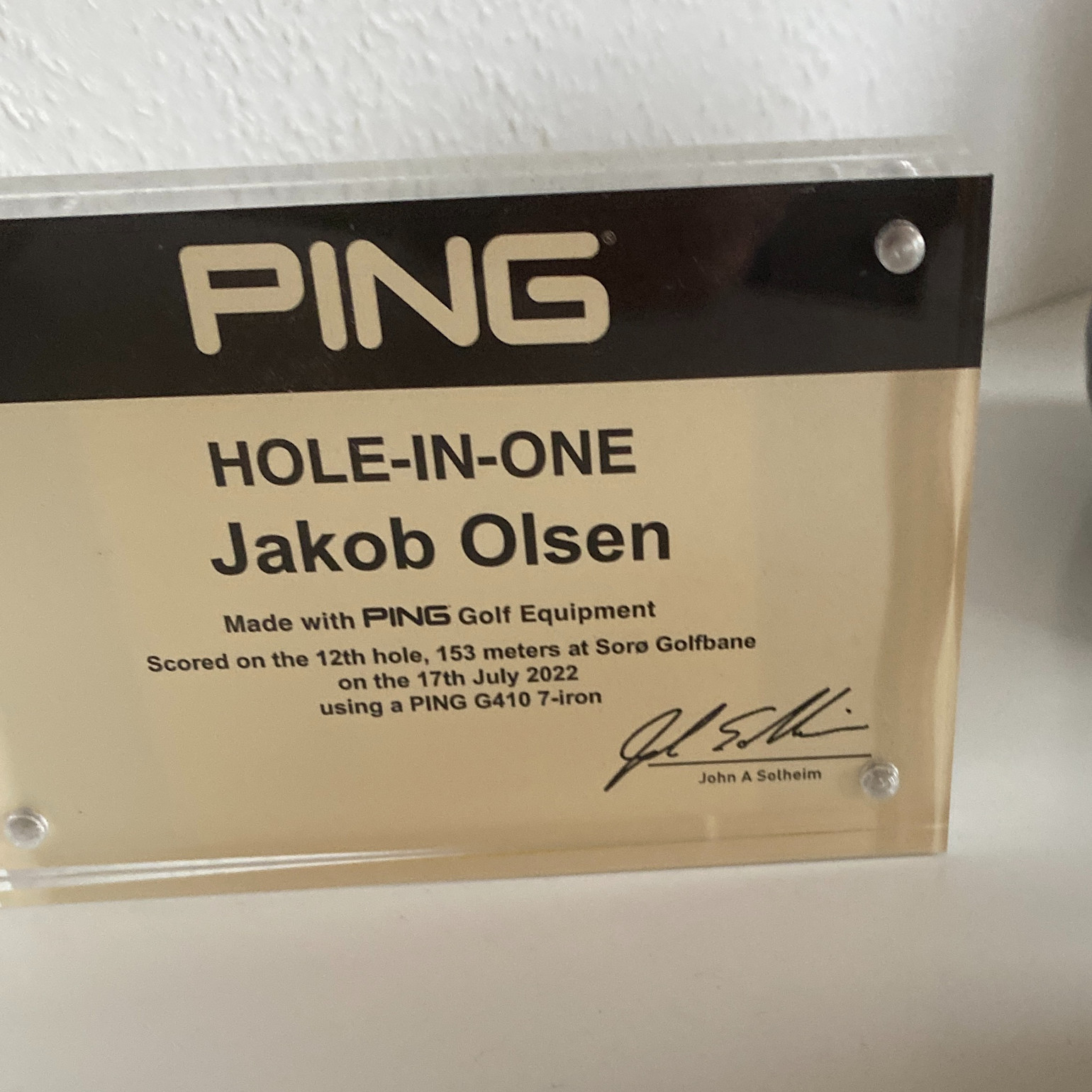 Plakette med teksten "PING HOLE-IN-ONE Jakob Olsen", detaljer om hole-in-one på Sorø Golfbane den 17. juli 2022, samt en signatur.