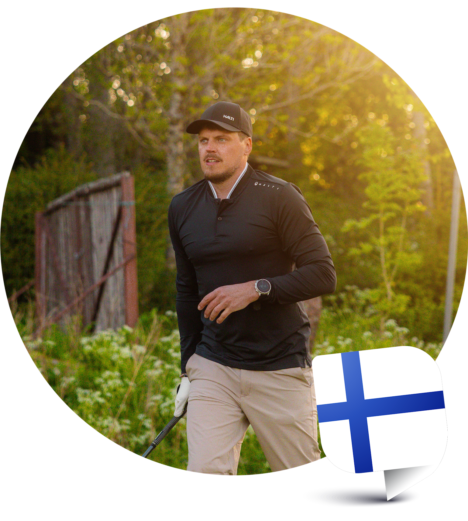 Ein Mann mit schwarzem Pullover und Mütze spielt Golf im Freien bei sonnigem Wetter, mit der finnischen Flagge in der Ecke.